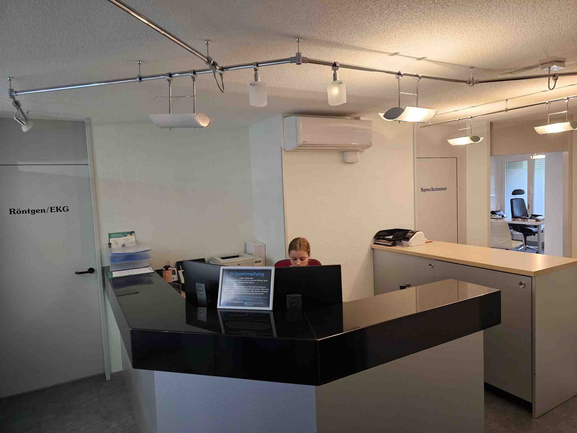 Heller und freundlicher Empfangsbereich der Arztpraxis.